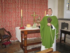 Revd Ian Finn at the altar following the finial's dedication at harvest festival Finials